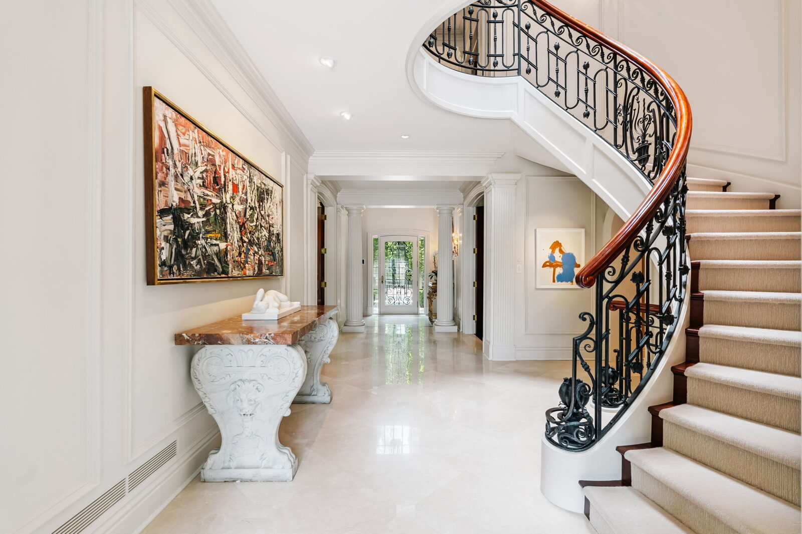 Curved staircase with wrought iron railing and contemporary art